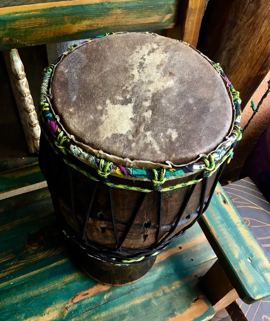 A wooden djembe, also known as Kongoma, sitting on top of a wooden bench.