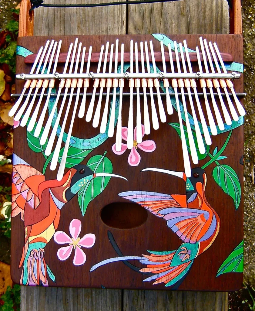 A Kongoma musical instrument, intricately adorned with hummingbirds and flowers.