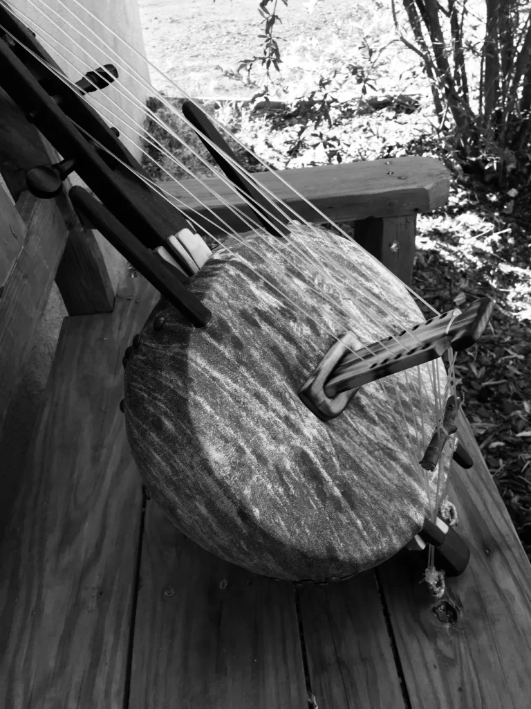 A wooden bench with a guitar on it, perfect for enjoying the soothing sounds of Ngoma or African music.