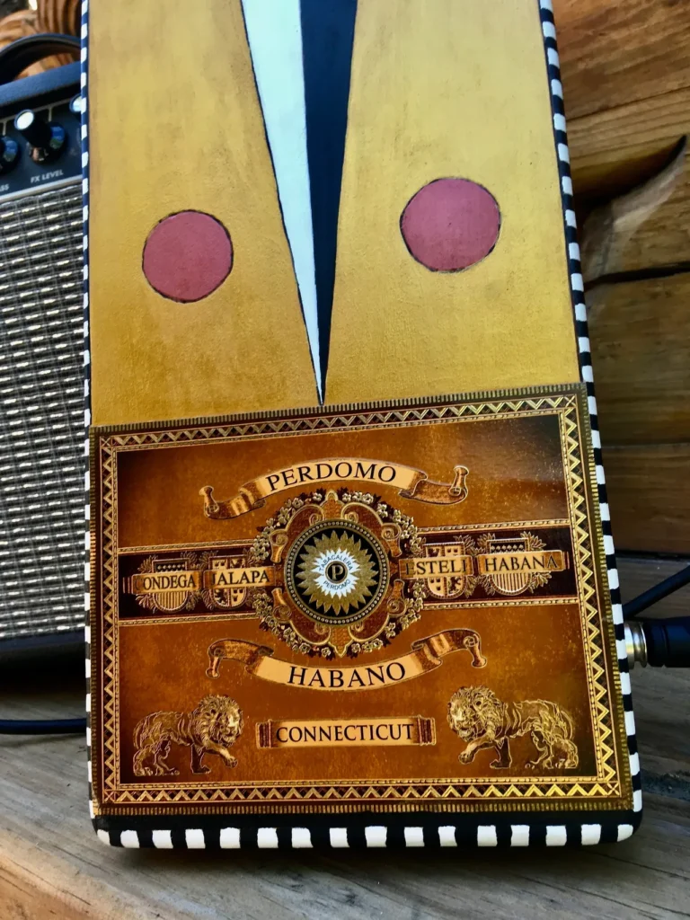 A wooden box with a gourd instrument sitting on top of it.