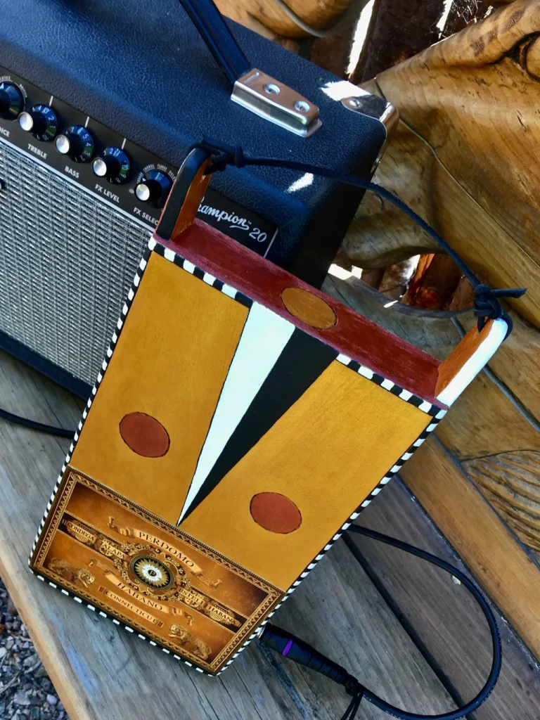 A gourd instrument resting atop a wooden box.