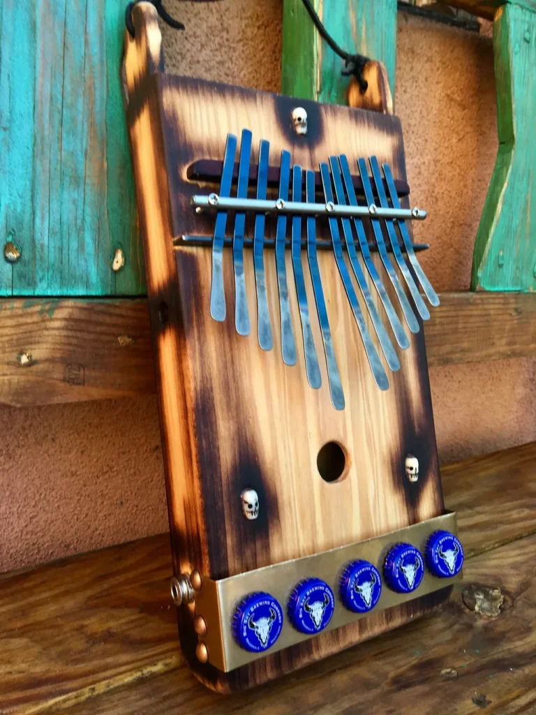 A wooden lamellaphone instrument with blue buttons on it.