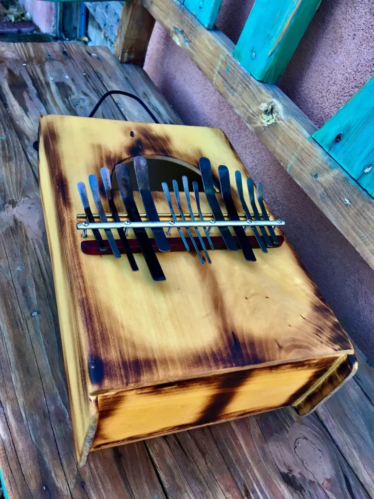 A wooden box with a set of knives on it, resembling a Kalimba in its compact and resonant design.