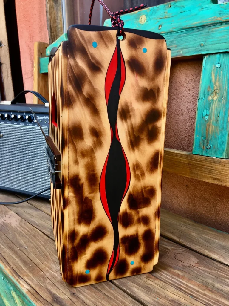 A wooden box with a leopard print on it sits on a wooden bench, surrounded by African drums.