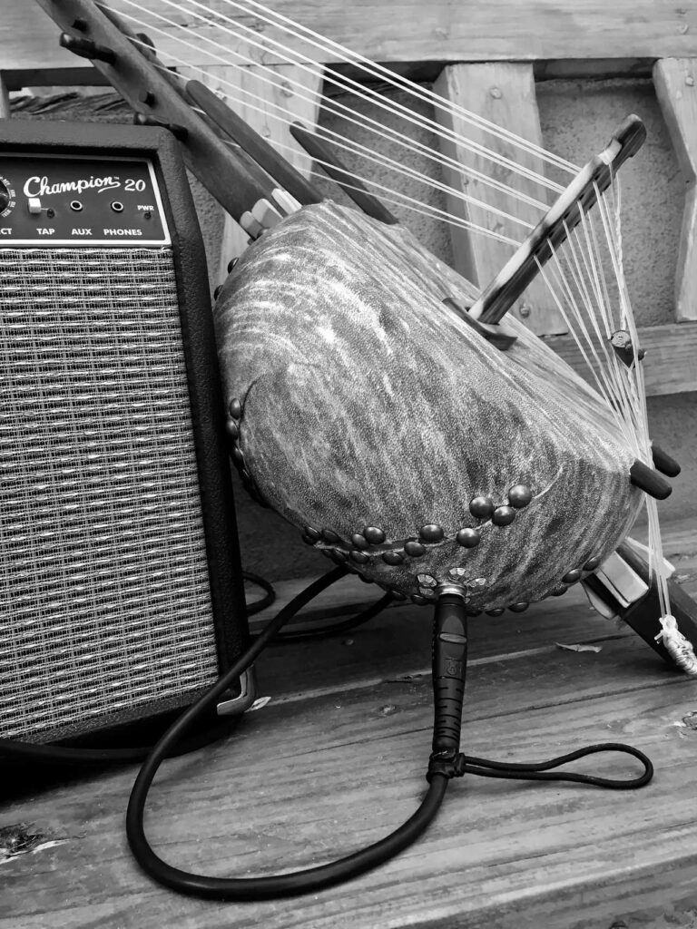 A black and white photo of a harp on a wooden bench, showcasing the beauty of African Music.