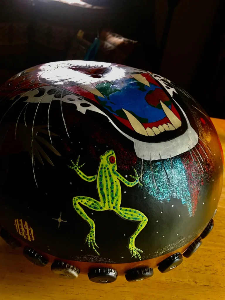 A drum decorated with a frog and a tiger, inspired by African harps and Ilimba.