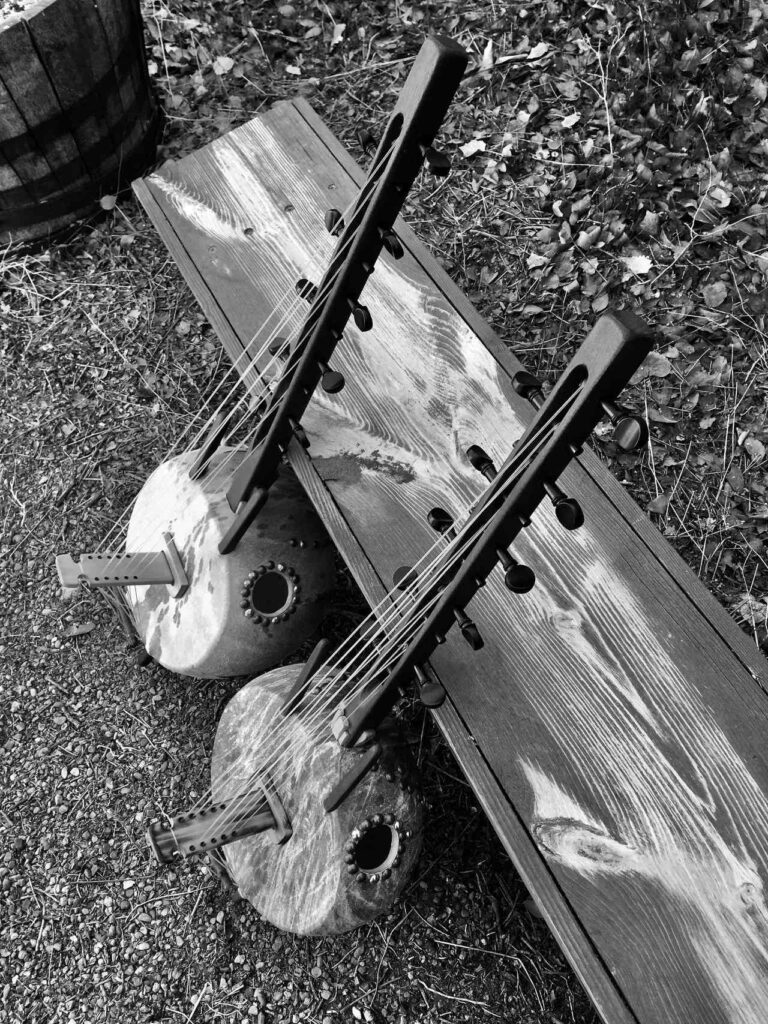 A black and white photo of two guitars on a wooden bench, capturing the essence of Ngoma music.