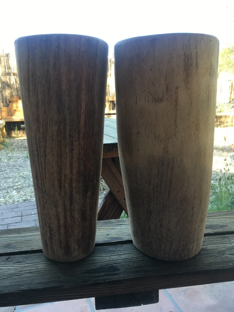 Two wooden vases made of African Ilimba wood sitting on a wooden table.