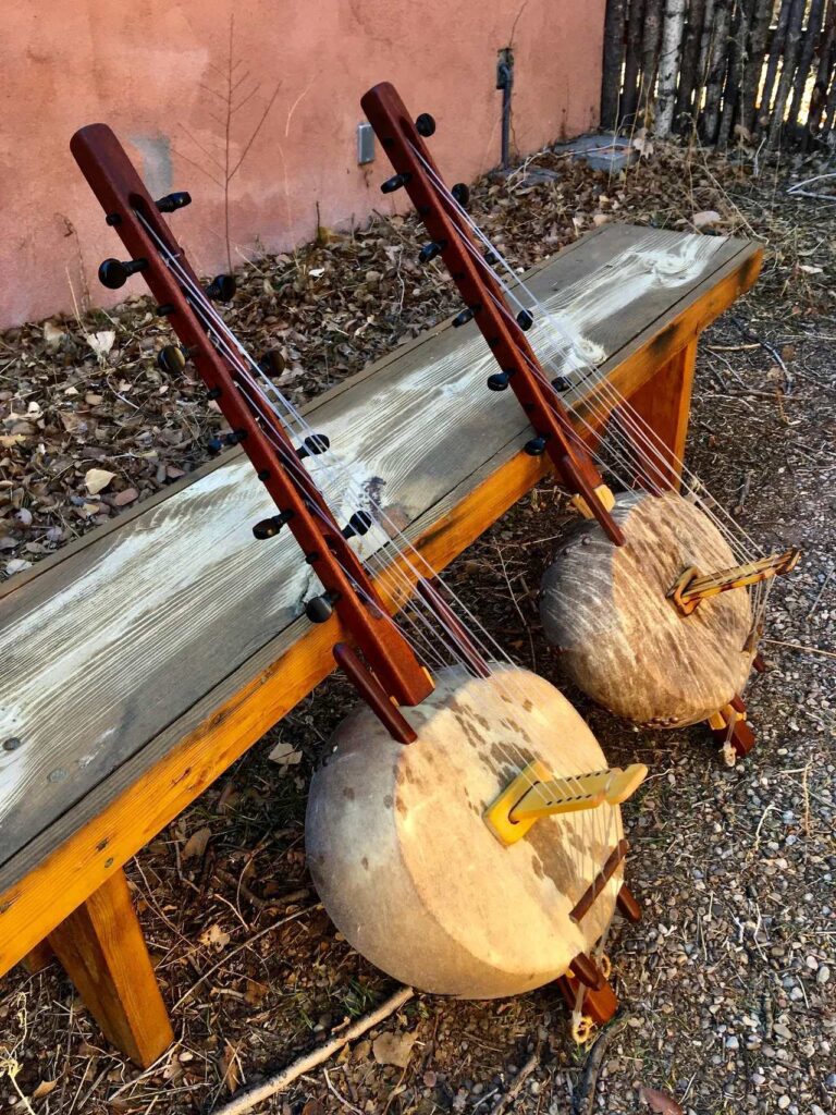 Two Ngoma drums sitting on a wooden bench.