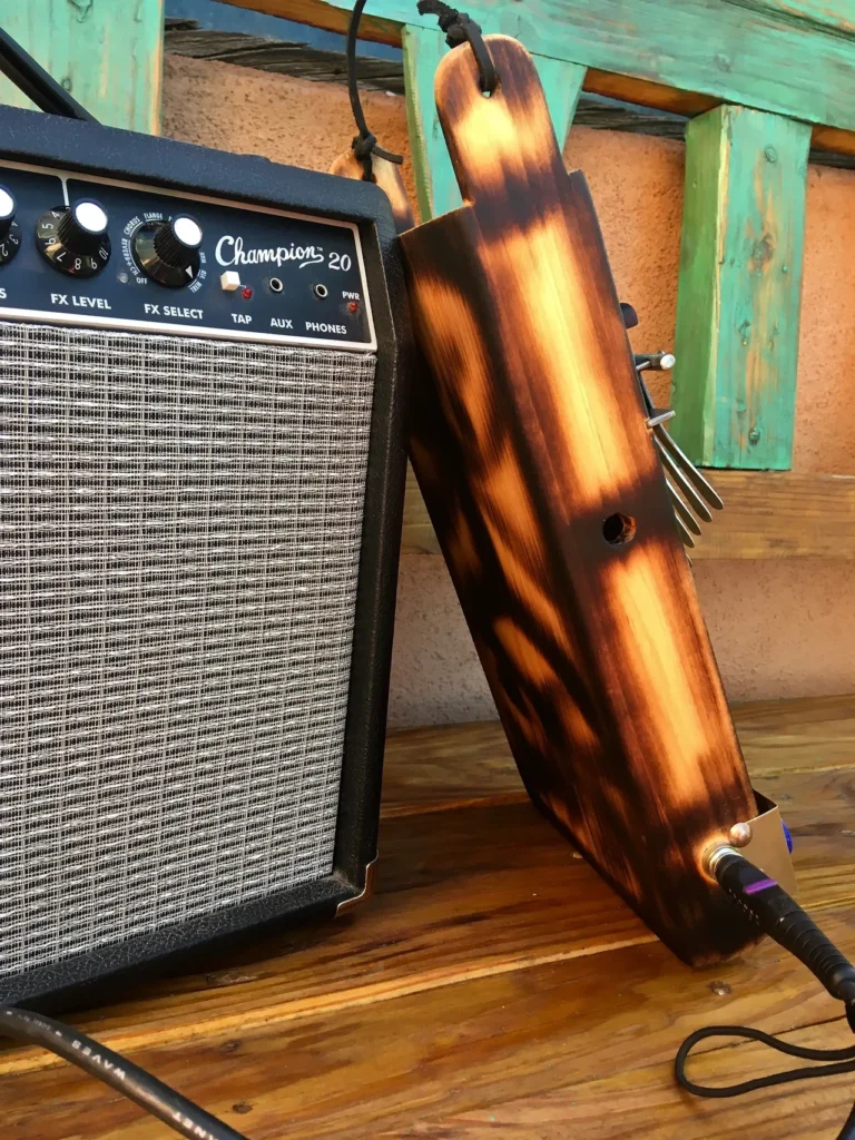 A guitar amplifier sitting on top of a wooden table next to a gourd instrument.