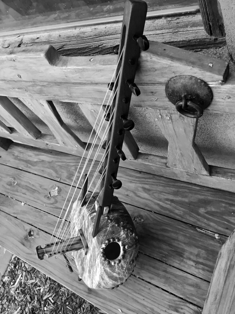 A black and white photo of a Ngoma, an African musical instrument, on a porch.