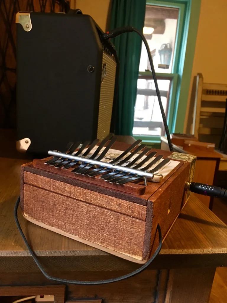 A lamellaphone, resembling an accordion, sitting on top of a wooden table.