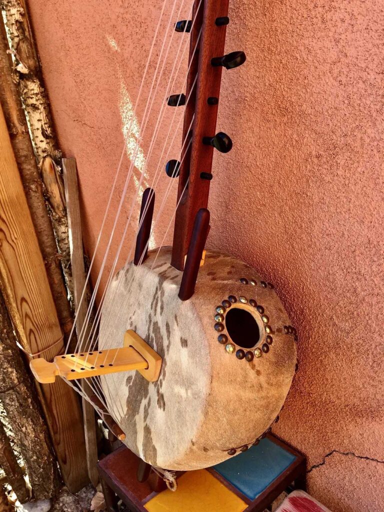 An Ngoma, a traditional African instrument made of wood, adorned with intricate carvings and featuring a single string attached to it.