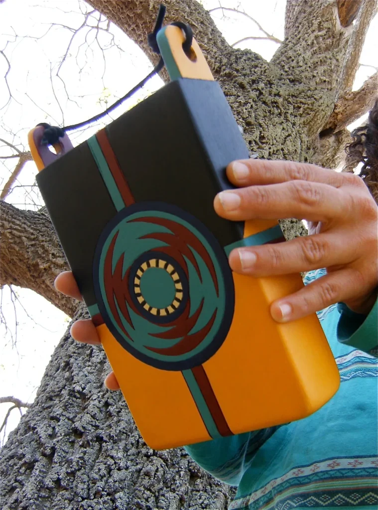 A woman is holding a black and yellow case filled with Ngoma, African Music.