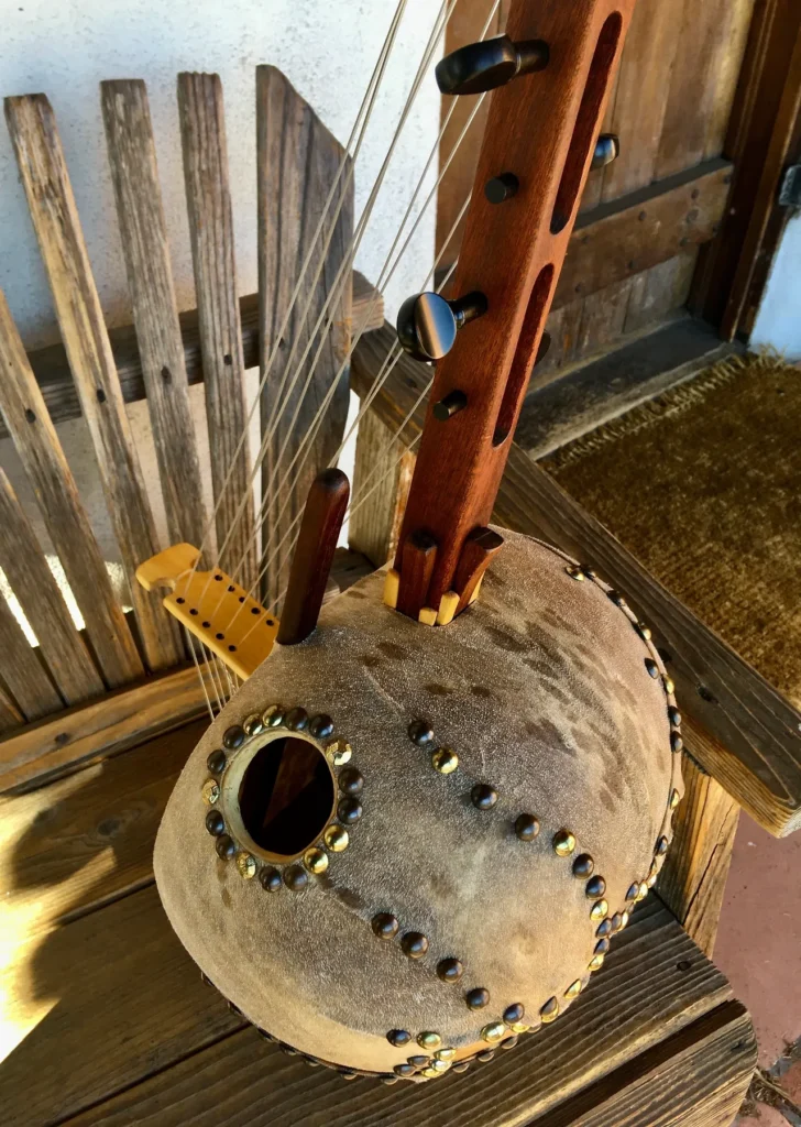 An intricately carved ngoma, a traditional African music instrument, gracefully rests on a rustic wooden bench.