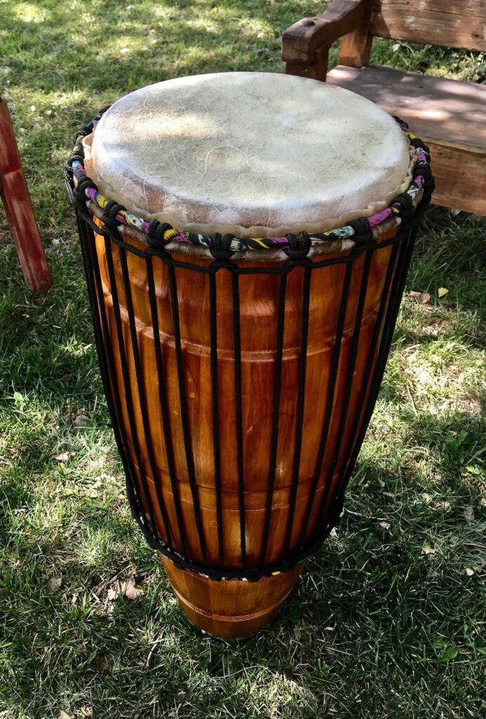 An Ilimba djembe sitting on a grassy area.