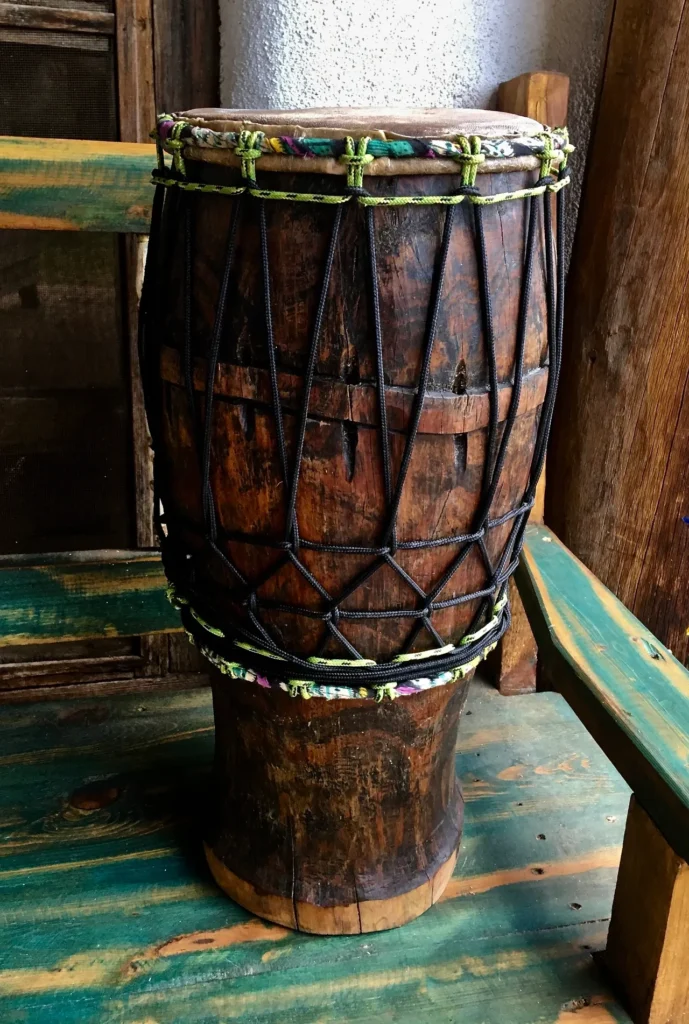 An Ilimba djembe sitting on top of a wooden bench.