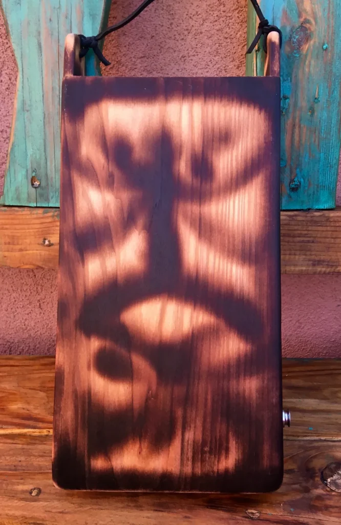 A wooden bag with a face on it, resembling a gourd instrument.