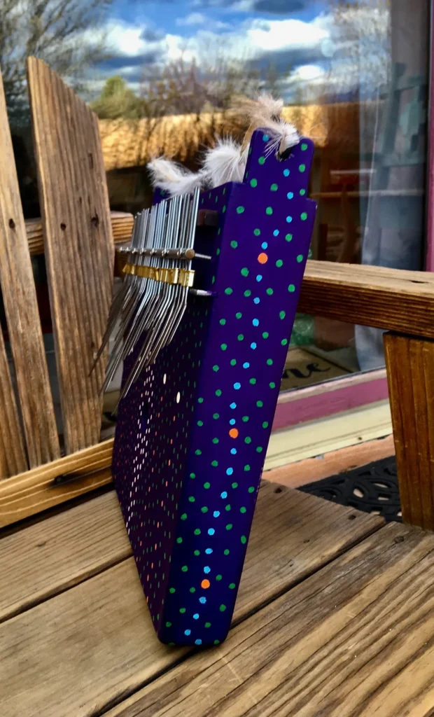 A purple polka dot bag resting on a wooden bench.