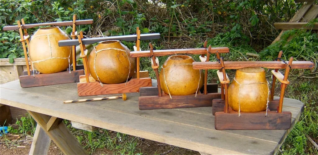 Four wooden vases, resembling Gourd Instruments, sitting on a wooden table.