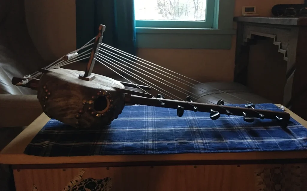 A Ngoma, a traditional African music instrument, sits atop a wooden table in front of a window.