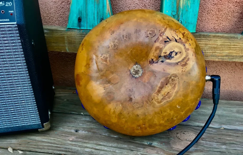 An Ilimba drum sitting on a wooden table next to a speaker.