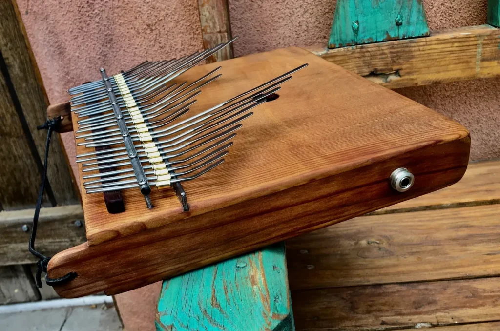 A gourd lamellaphone is sitting on top of a wooden bench.