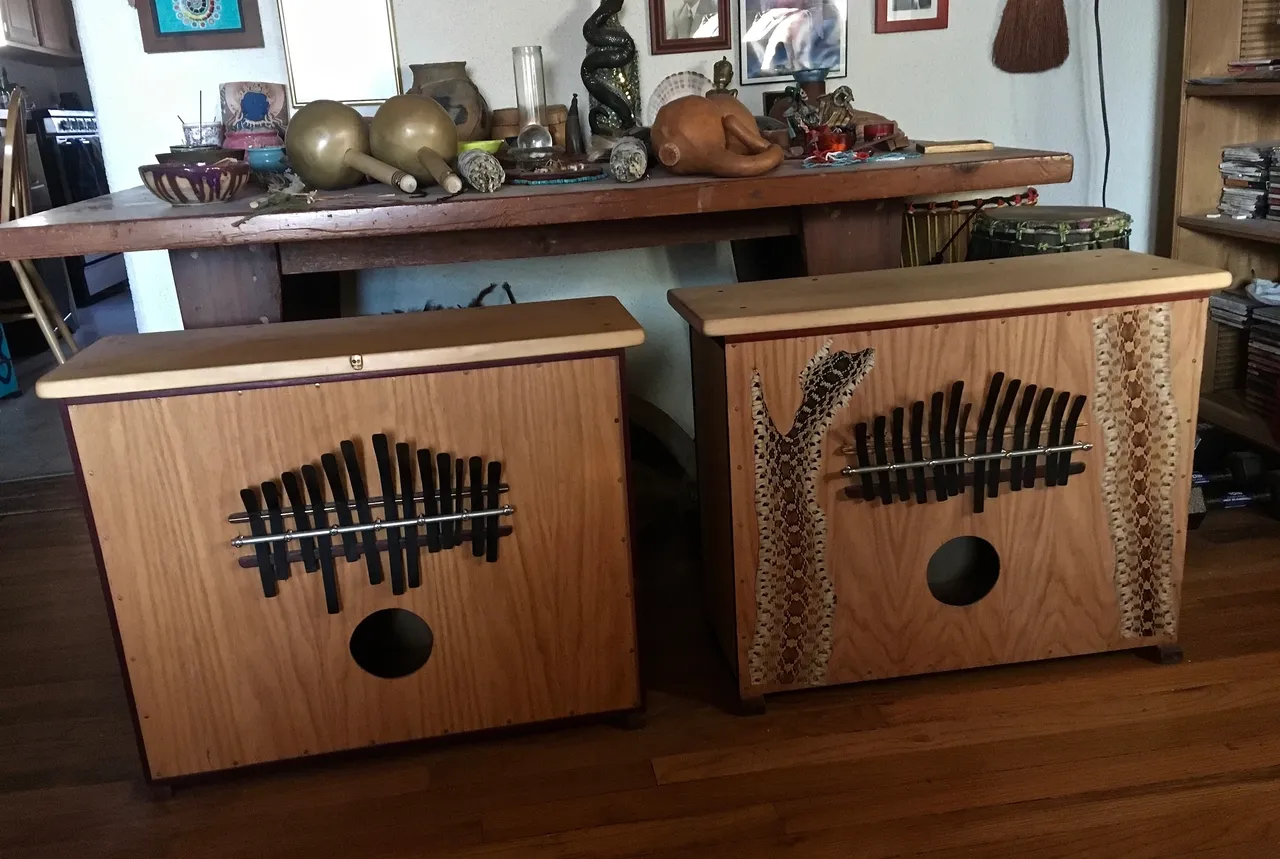 Two wooden boxes, resembling African drums, sitting on top of a wooden floor.