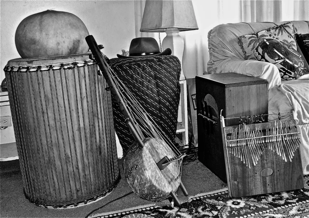 A black and white photo of a living room adorned with various musical instruments, including Ngoma drums that exude the essence of African music.