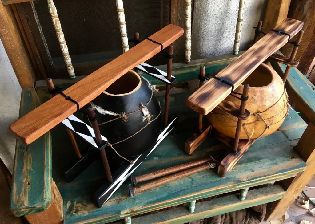 Two gourd instruments sitting on a wooden bench.