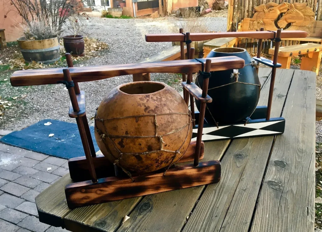 Two wooden gourd instruments sitting on a wooden table.