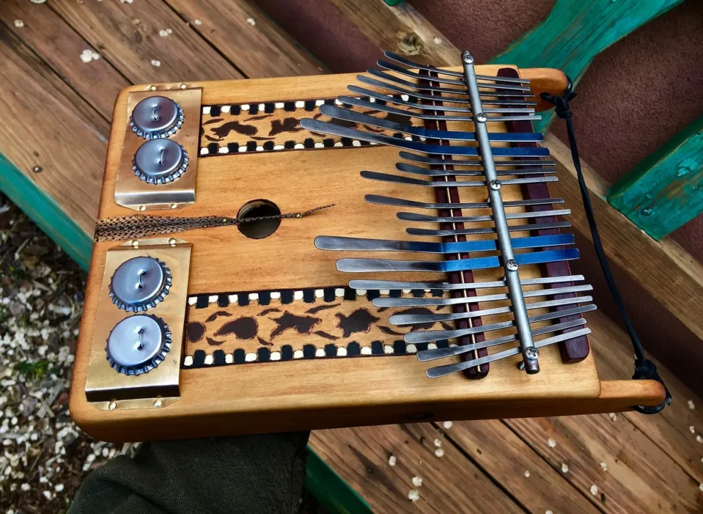 A person is holding a lamellaphone, a wooden musical instrument.