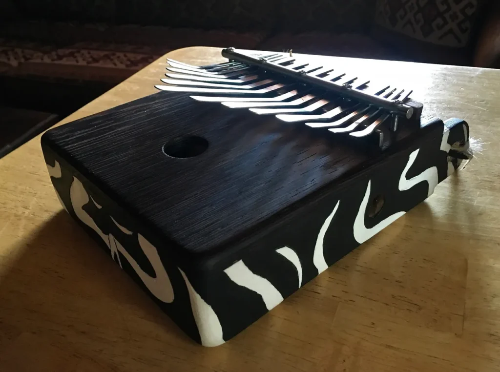 A black and white accordion, also known as Ngoma, sitting on top of a table.