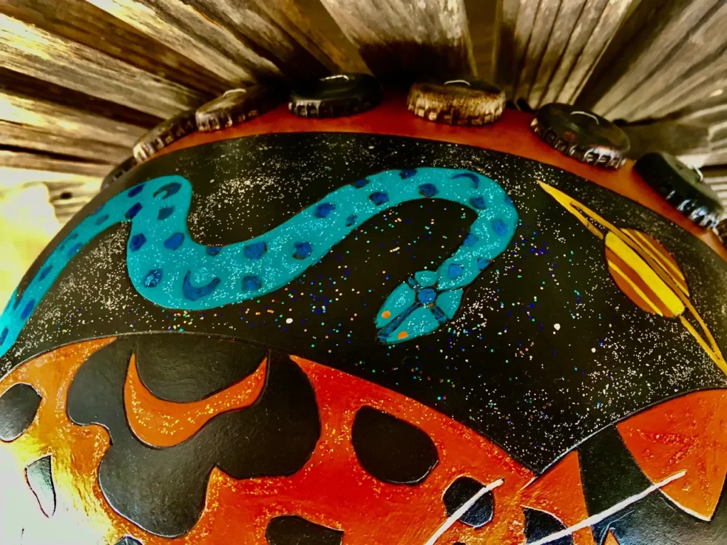 An African drum with a snake on it.