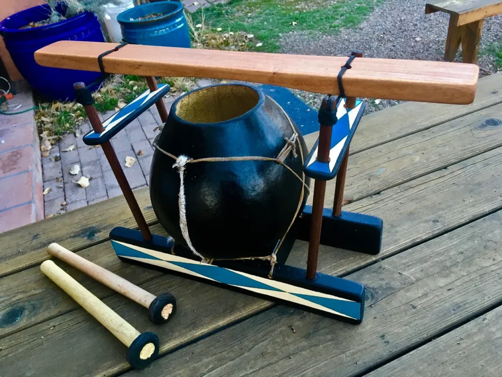 A wooden lamellaphone with a wooden stick on top.