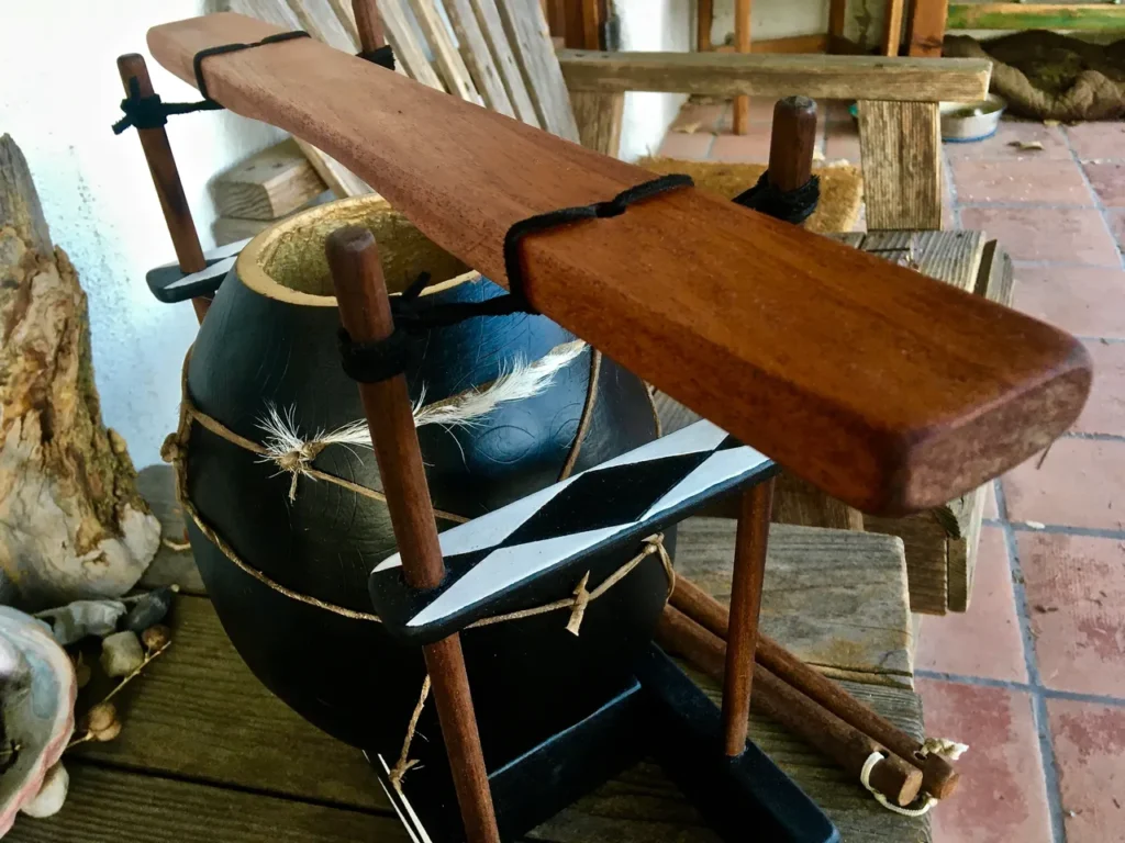 A Gourd Instruments drum is sitting on a wooden stand.