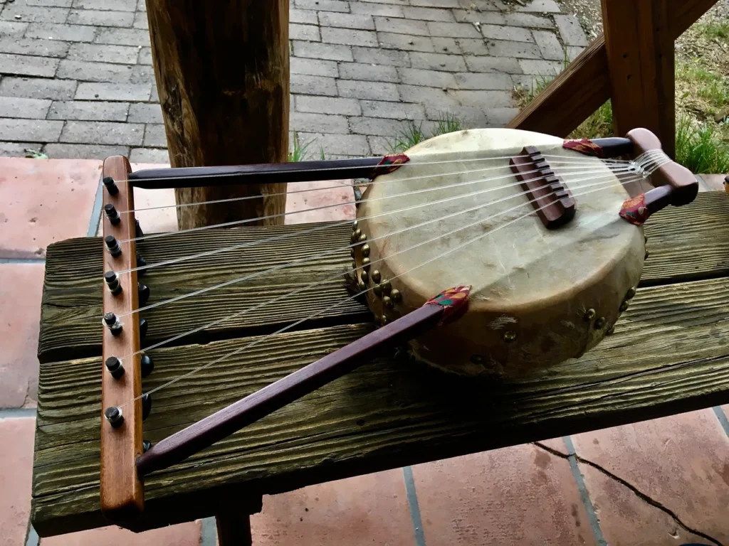 A wooden instrument, the Kalimba, is sitting on top of a wooden bench.