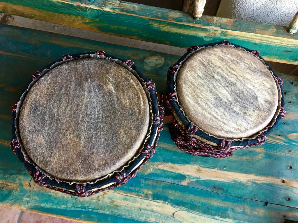 Two wooden djembe drums, reminiscent of African harps, placed gracefully on a wooden table.