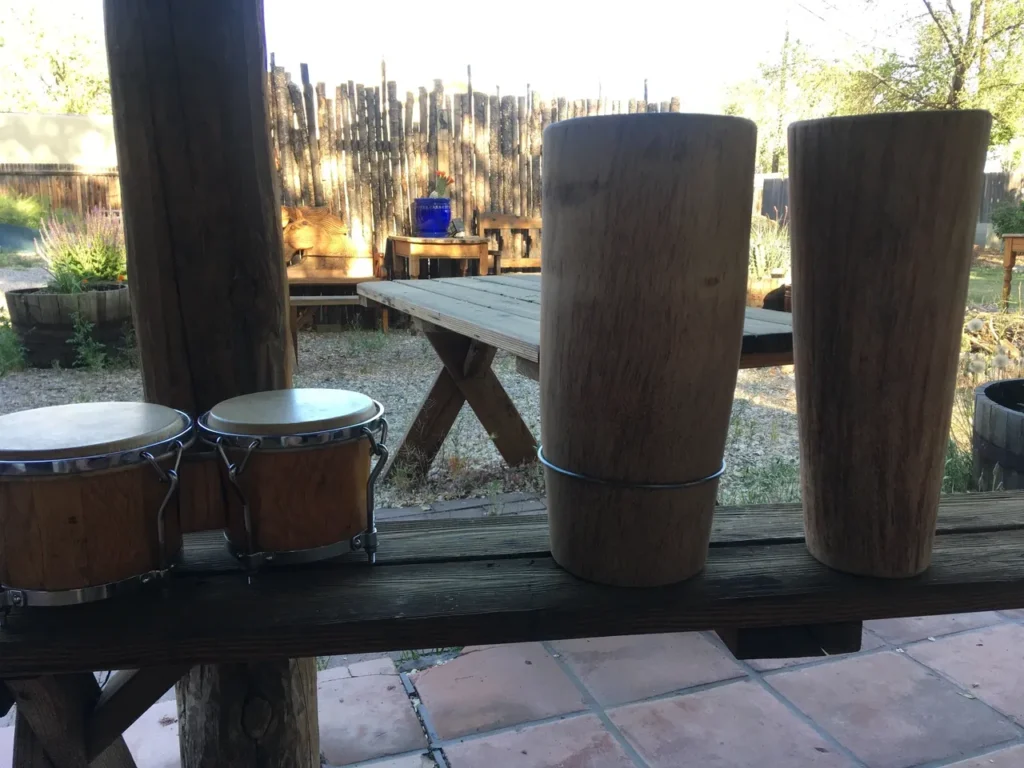 Two wooden drums, resembling African harps, sitting on a wooden table.