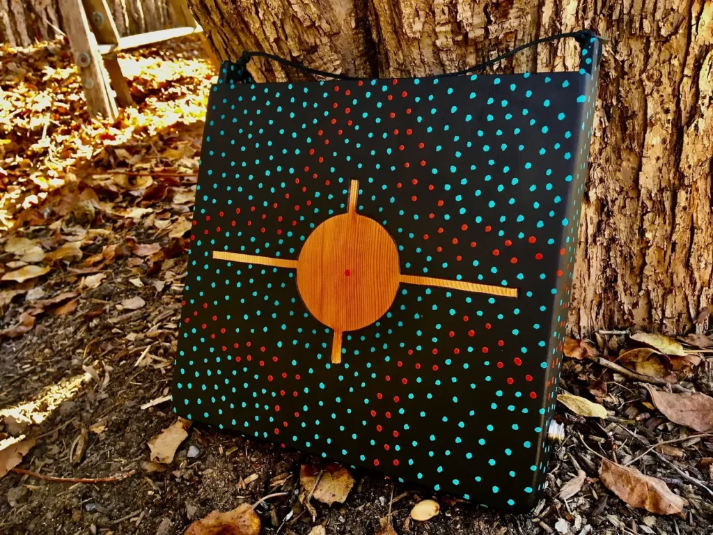 A Kongoma bag with a star on it sitting on a tree.