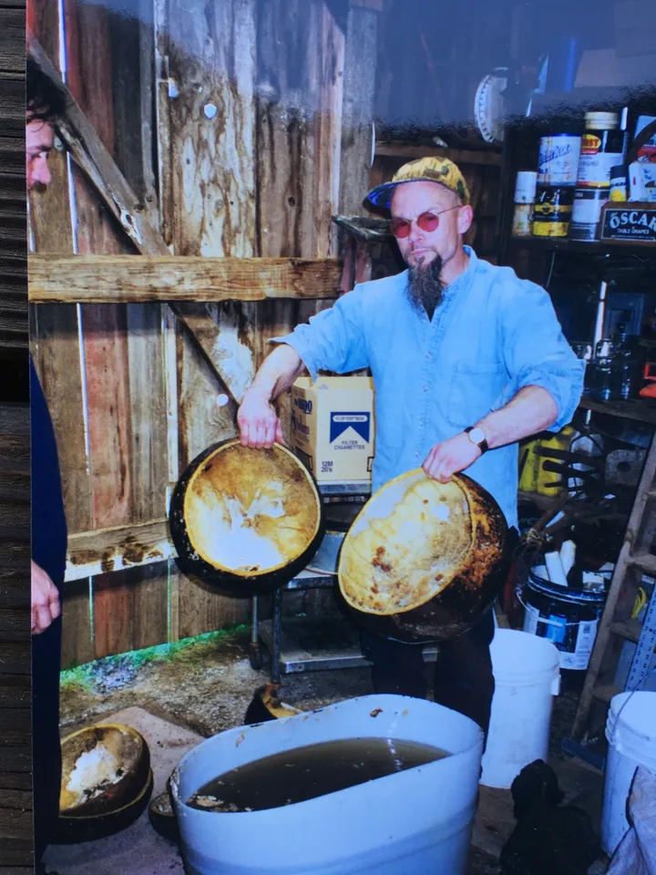 Two men standing in a barn with Ngoma drums.