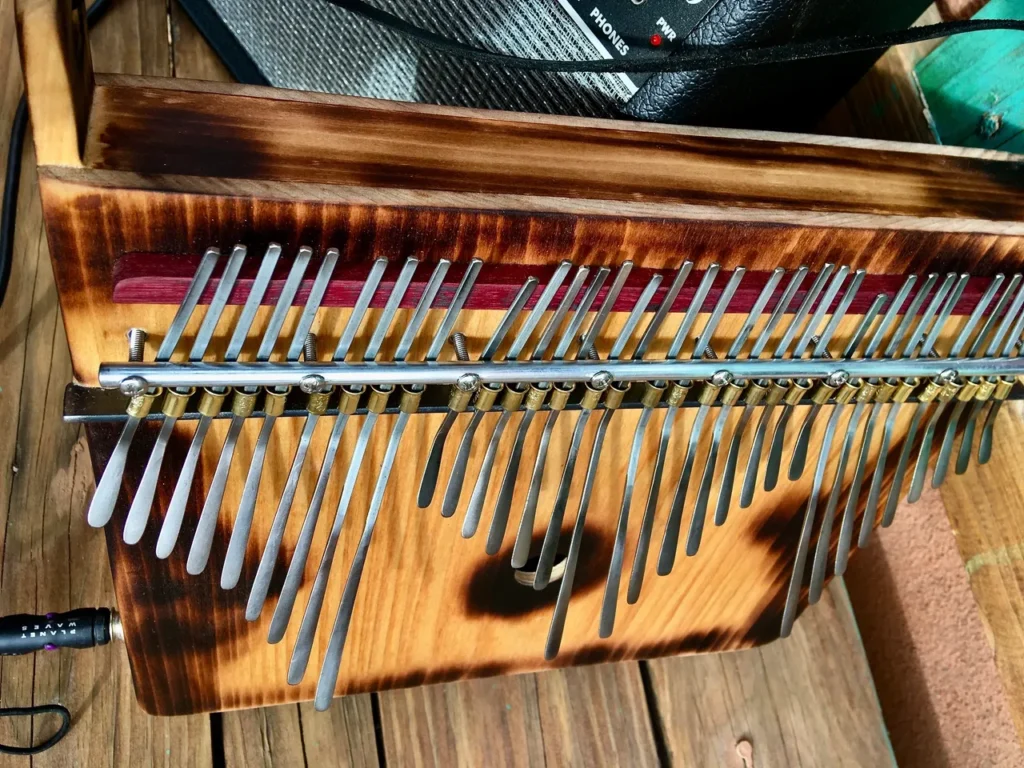 A wooden lamellaphone is sitting on a wooden deck.