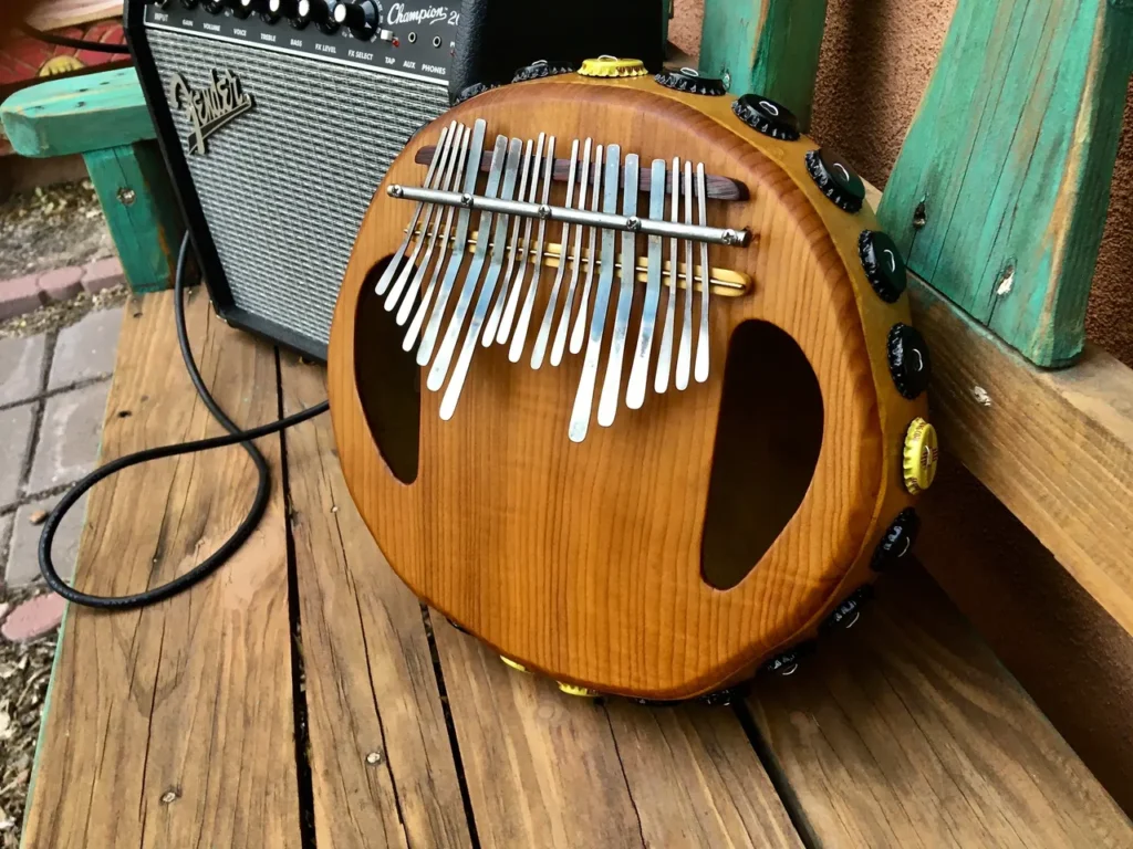 A wooden ukulele, a gourd instrument, is sitting on a wooden bench.