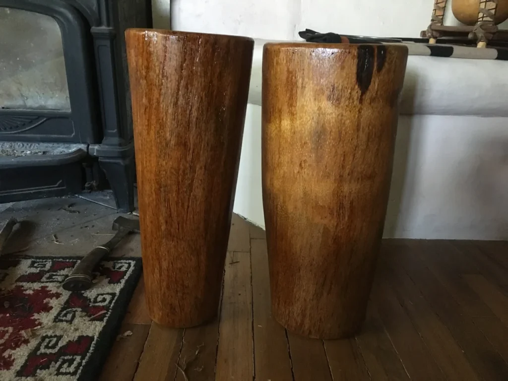 Two large wooden Ilimba vases on an African harps wooden floor.