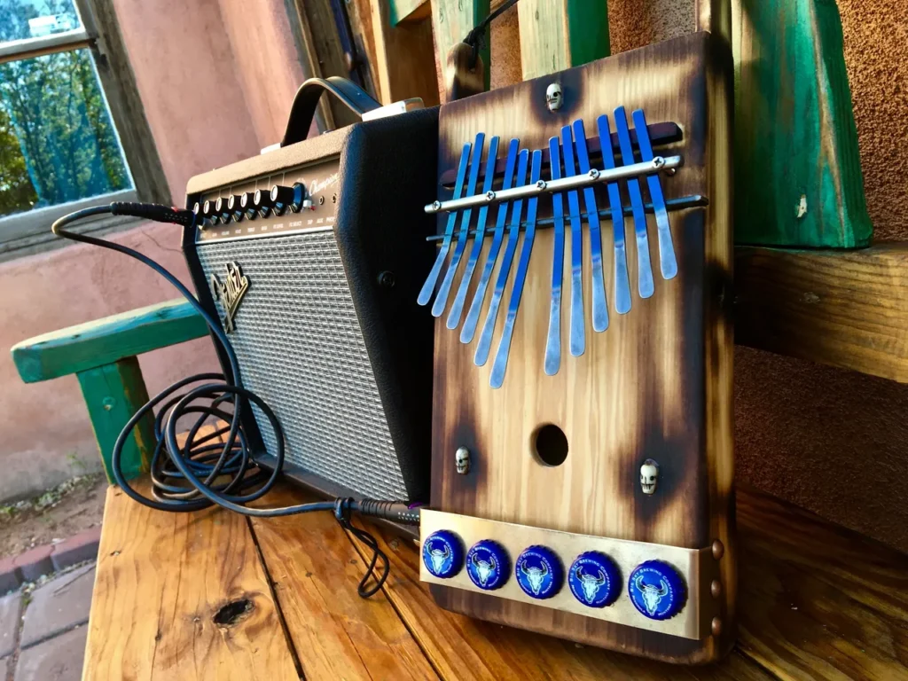 A Lamellaphone instrument, made out of gourd, is sitting on a wooden bench.