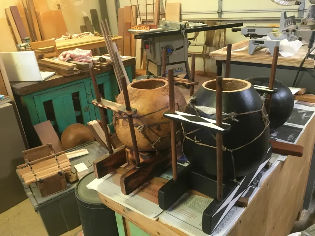 A wooden bowl, resembling gourd instruments, is sitting on a table in a workshop.