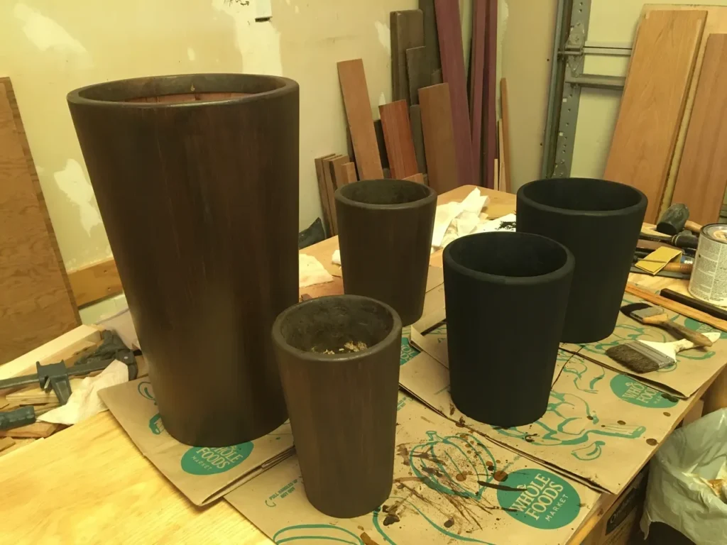 A group of African wooden vases on a table in a workshop.