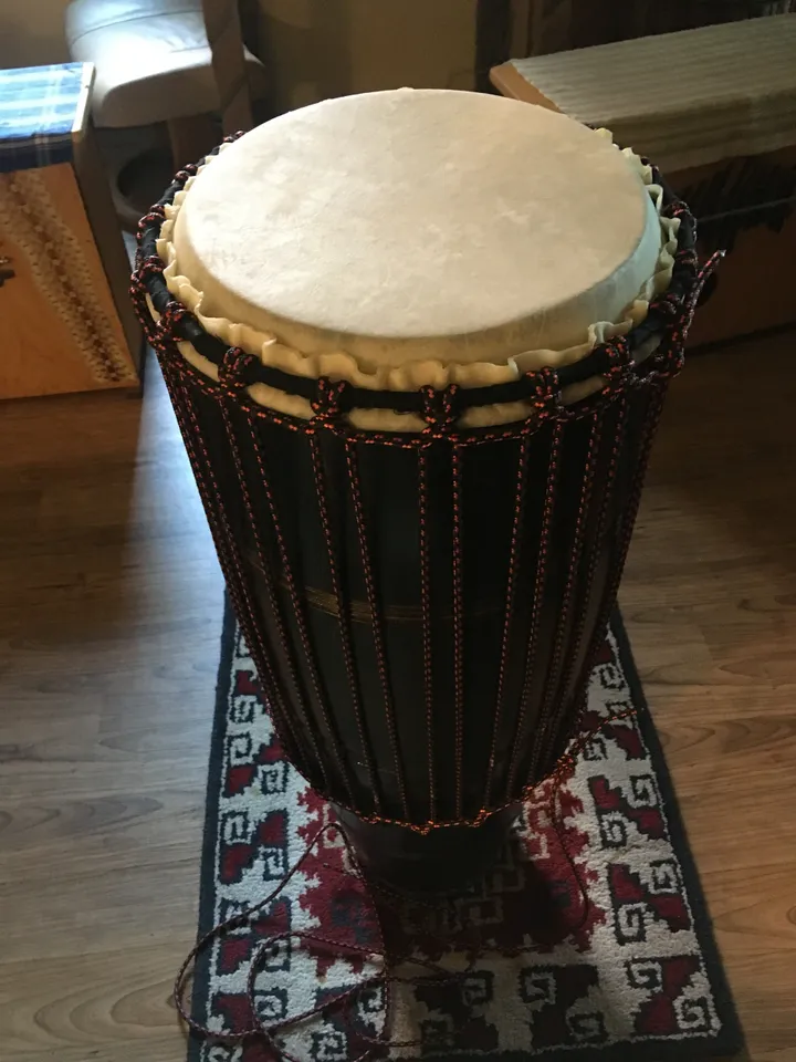 An Ilimba drum sitting on a rug in a living room.