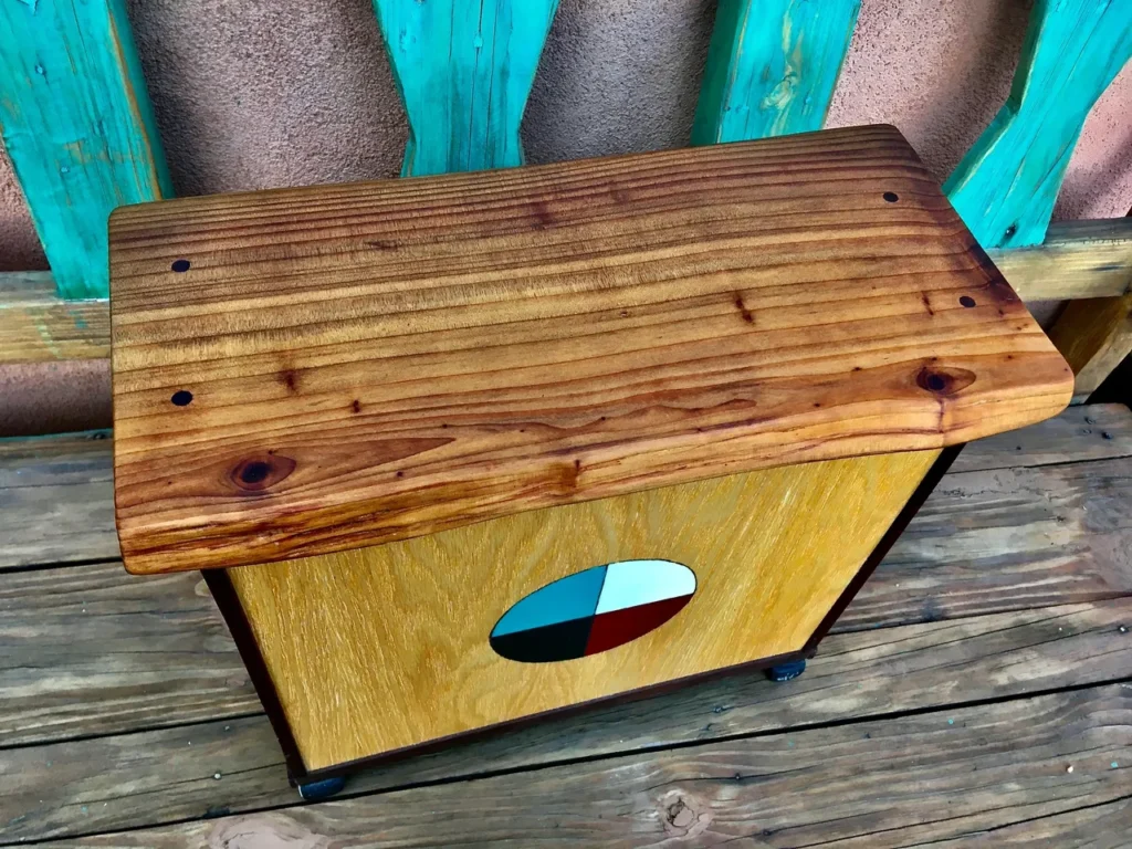 A wooden box with a red, white, and blue design on it, reminiscent of the colors found on African drums.