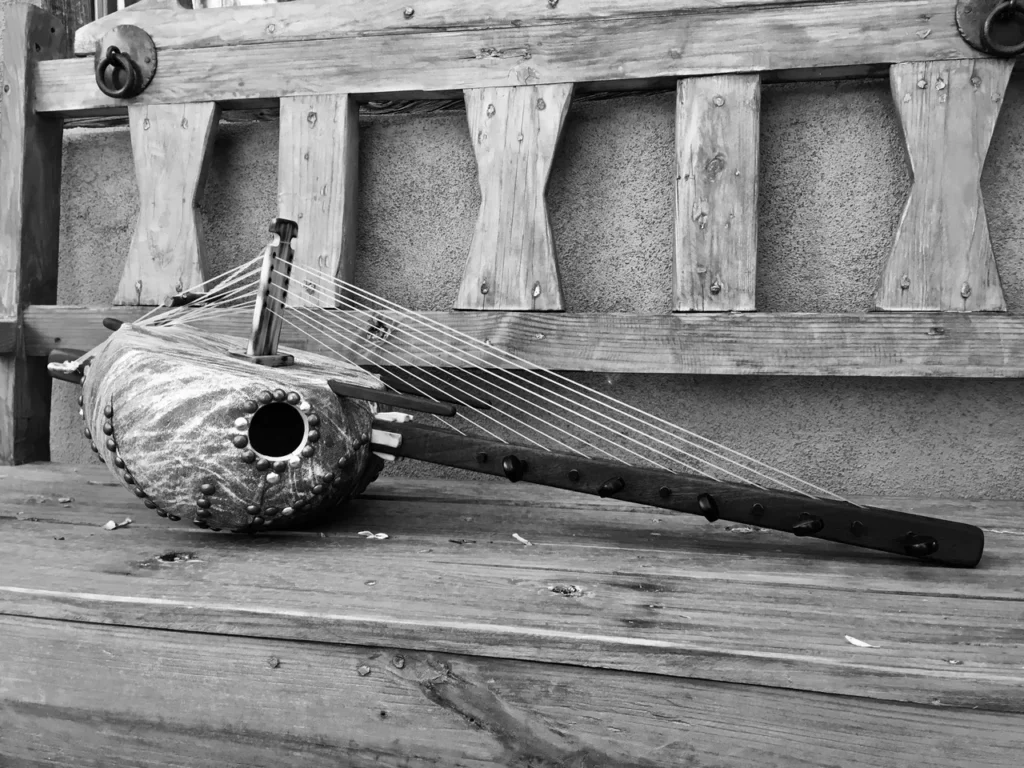 A black and white photo of an Ngoma, a musical instrument, on a wooden bench.